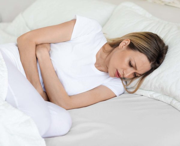 Sick woman suffering from abdominal pain in the morning